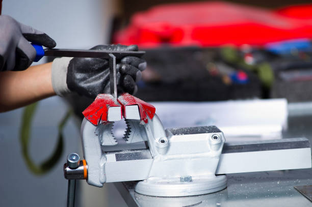 istock gloved hands work on a metal workpiece clamped in a vice 1171538942