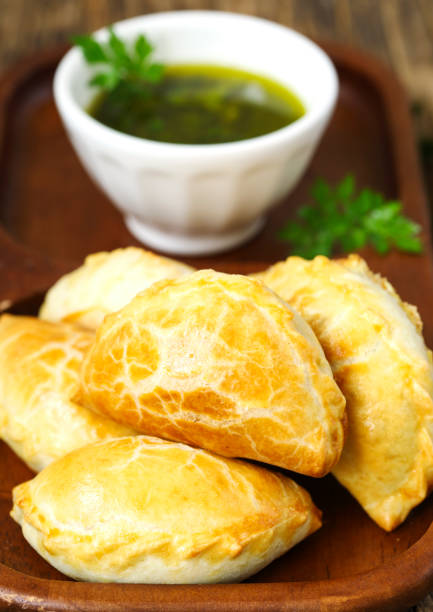 istock Empanadas with chimichurri sauce on wooden table 1171539020