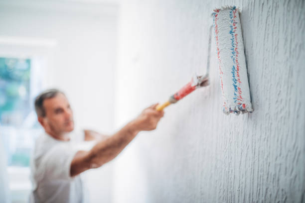 istock Senior painting walls in white 1171539099