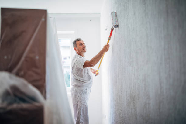 istock Senior worker painting living room 1171539154