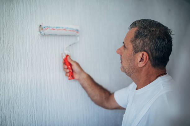istock Senior worker painting walls in white 1171539763