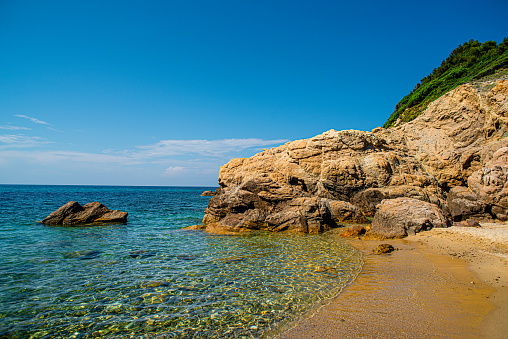 Crystal clear sea and the picturesque rocky beach in Skiathos, Greece