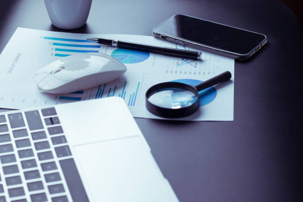 istock A desk, a black desk with a computer, a graph, a magnifying glass, and a calculator. 1171543459