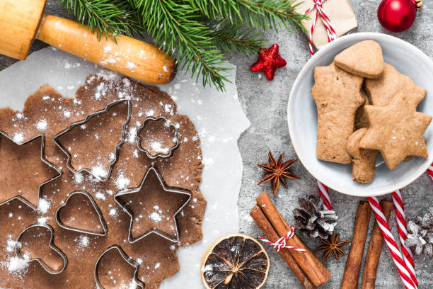 istock Christmas gingerbread cookies with fir tree branches, gift boxes and decorations on gray concrete background. top view 1171544392
