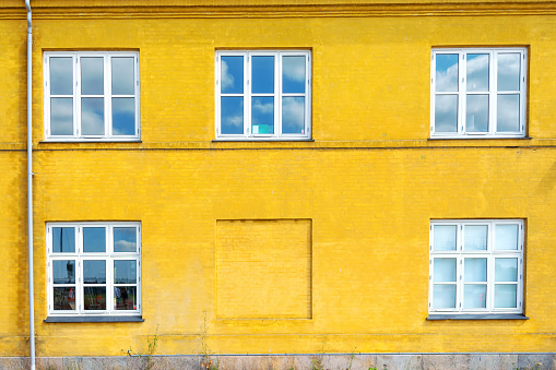 Beautiful white wooden windows on a yellow brick wall. Architecture. Details Exterior.