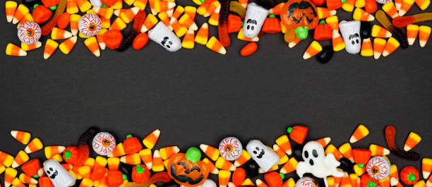 Halloween candy double border banner on a black background with copy space Halloween candy double border banner. Top view on a black background with copy space. eye candy stock pictures, royalty-free photos & images
