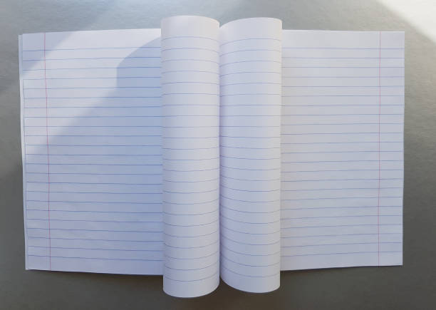 istock open school notebook with pen on a gray desk with sun rays from the window. A blank, white sheet of notebook for writing. education concept. Copy space. view from above. Flat lay 1171555723