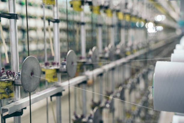istock White yarn spools bobbin thread cones on industrial warping beaming machine in textile factory 1171556460