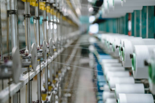istock White yarn spools bobbin thread cones on industrial warping beaming machine in textile factory 1171556468