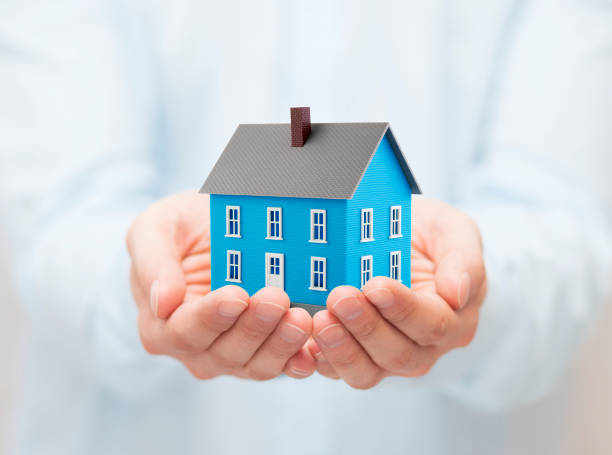 istock Small blue toy house in hands 1171564894