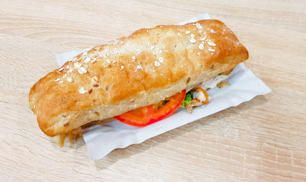 istock Ciabatta sandwich with lettuce, chicken and cheese on a wooden table 1171566949