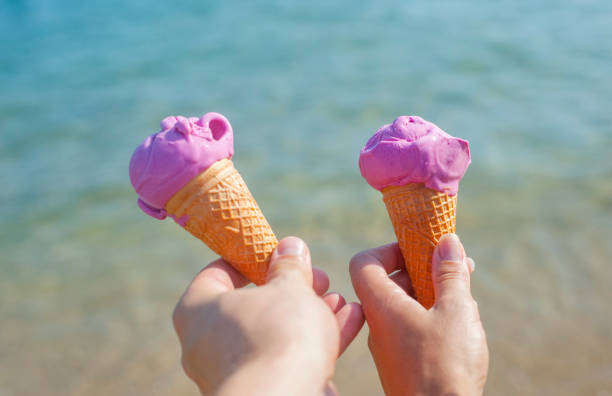 istock hands holds tasty ice cream on a summer beach. 1171573286