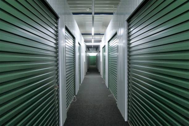 Hallway storage units hallway of self storage units for rent with green rolling doors storage compartment stock pictures, royalty-free photos & images