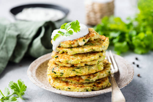 Vegetable zucchini fritters with sour cream stock photo
