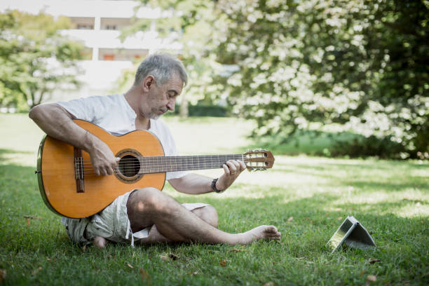 istock Senior flamenco guitar player practicing his art in a public park 1171580183