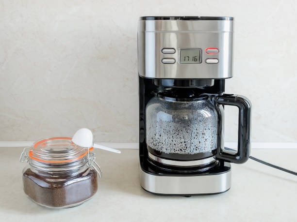 istock And finally drip-type coffee maker brews coffee for the first time. Red button indicates process is going on. Hot coffee is in glass jug. Home electrical appliances. Domestic life. 1171584483