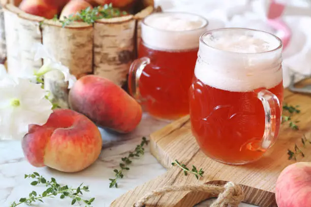 Two mug of light fruit craft beer and fruits