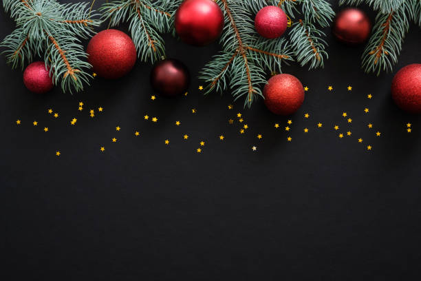 istock Christmas dark black background with red baubles, Christmas decorations, fir tree branches, confetti star. Xmas frame border, top view, copy space. Greeting card mockup. 1171586229
