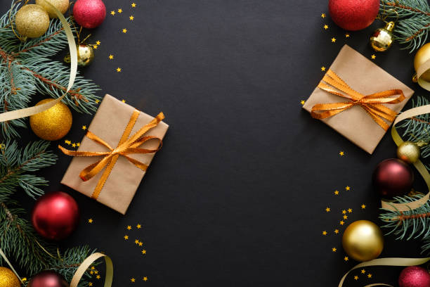 istock Christmas composition. Golden and red balls, modern festive decorations, gift boxes, fir tree branches on dark black background. Elegant Christmas greeting card template. Flatlay, top view, copy space 1171586250