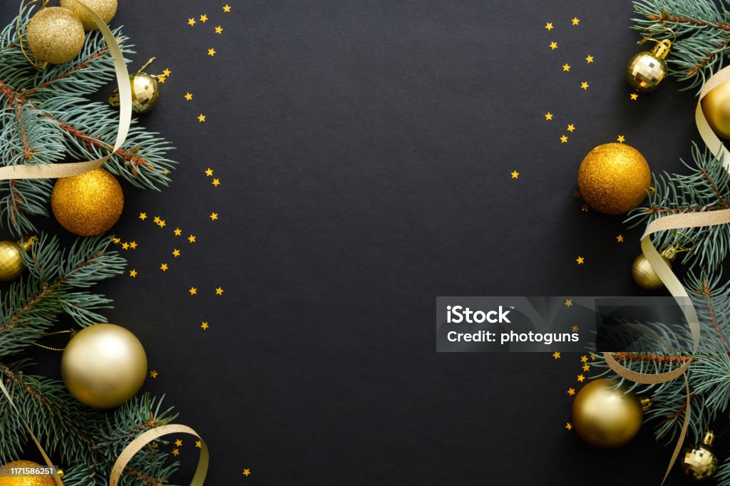 Black Christmas background with golden decorations, baubles, fir tree branches, confetti. Christmas holiday celebration, winter, New Year concept. Christmas banner mockup, greeting card template. Christmas Stock Photo