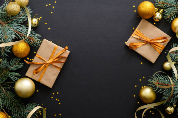 istock Christmas composition. Golden baubles, modern festive decorations, gift boxes, fir tree branches on dark black background. Elegant Christmas greeting card template. Flat lay, top view, copy space. 1171586284