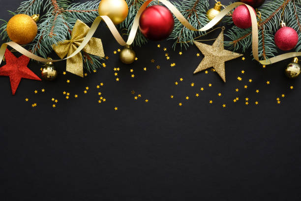 istock Christmas holiday composition. Festive Christmas decorations, baubles, fir tree branches, confetti star on dark black background with copy space. Banner mockup, postcard. Flat lay, top view, overhead 1171586293