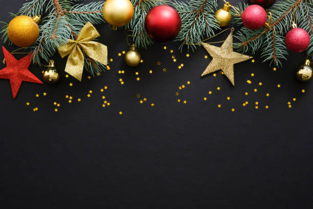 istock Christmas holiday composition. Festive Christmas decorations, baubles, fir tree branches, confetti star on dark black background with copy space. Banner mockup, postcard. Flat lay, top view, overhead 1171586307