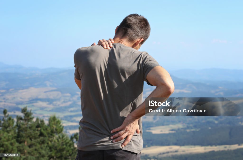 Rückenschmerzen Linderung. Mann Wanderer mit Rückenschmerzen - Lizenzfrei Rückenschmerzen Stock-Foto