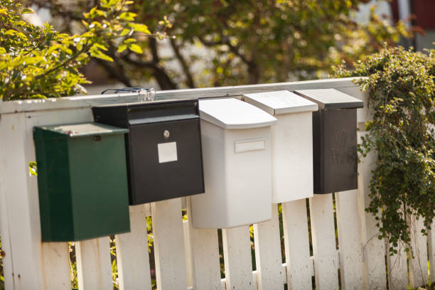 istock White and green mailboxes on a wooden white fence 1171590433
