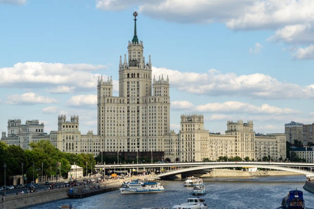 vue de coucher du soleil de gratte-ciel sur kotelnicheskaya embankment et rue de circulation sur moskvoretskaya embankment du pont flottant dans le parc de zaryadye. rivière moskva avec des bateaux de plaisance. - kotelnicheskaya photos et images de collection