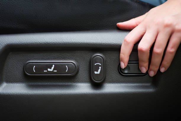 the girl s hand lies on the seat adjustment panel in the car