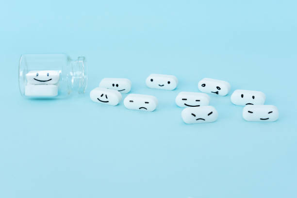 istock Pills with funny faces and a glass bottle on a blue background. 1171595424