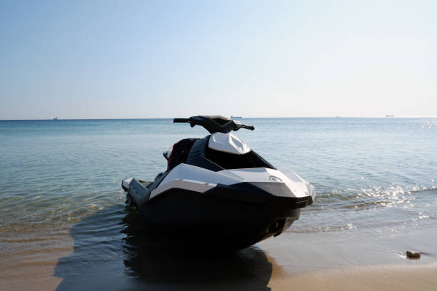 Black and white Jetski for rent parked on the beach.