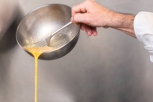 istock Chef pouring omelette mix into a hot frying pan. 1171608046