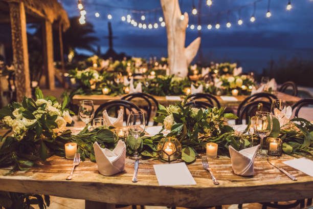 réglage de table à la cérémonie de mariage de nuit. décoration avec des fleurs fraîches, des bougies, des ampoules, des guirlandes. style vintage. - ambiance événement photos et images de collection