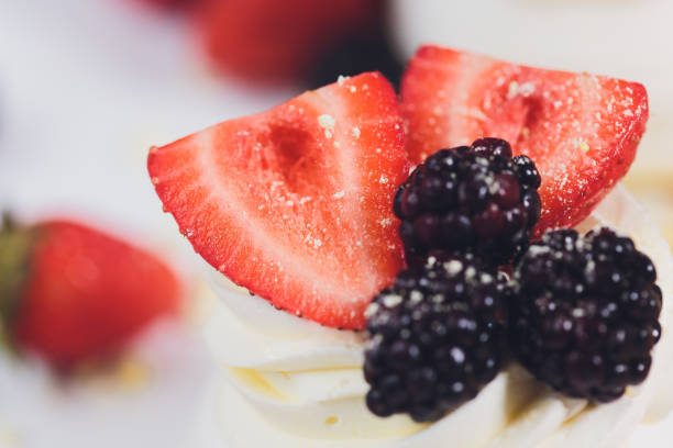 Dessert with berries on a meringue with cream.