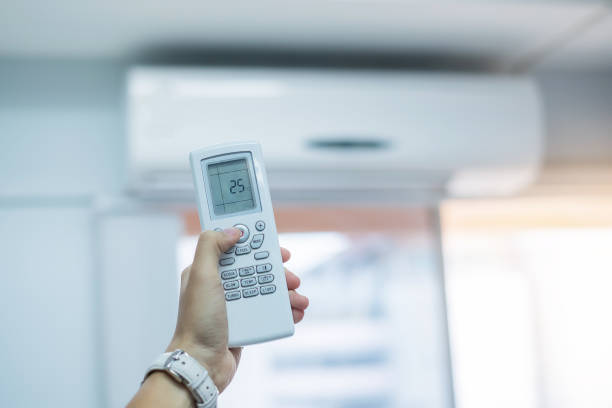 istock hand using remote controller for adjust Air conditioner inside the room of office or house 1171620348