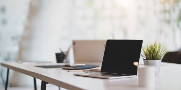 Open blank laptop in modern workplace with office supplies and decorations