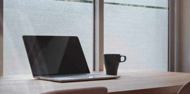 istock Open laptop computer with coffee cup on wooden table 1171623971
