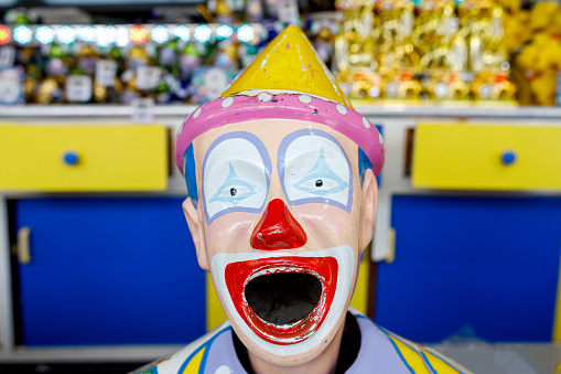 Clown manager office worker in wig and business suit dancing, celebrate, making silly faces at work. Guy businessman entrepreneur boss smiles. Expressions. Copy space. Halloween. Yellow background