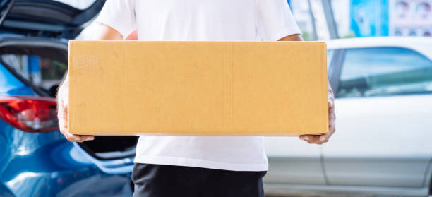 istock Delivery man carrying cardboard box for sending deliver to customer by transportation system hatchback car, Business of male transport sell part or product service parcel for convenience of customer 1171634304