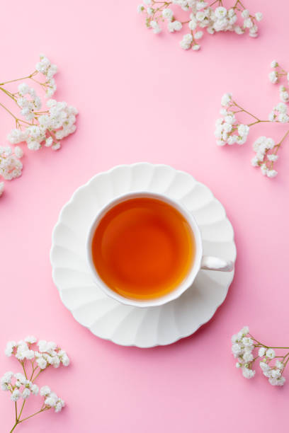 istock Cup of tea with fresh flowers on pink background. Top view. Copy space. 1171641370