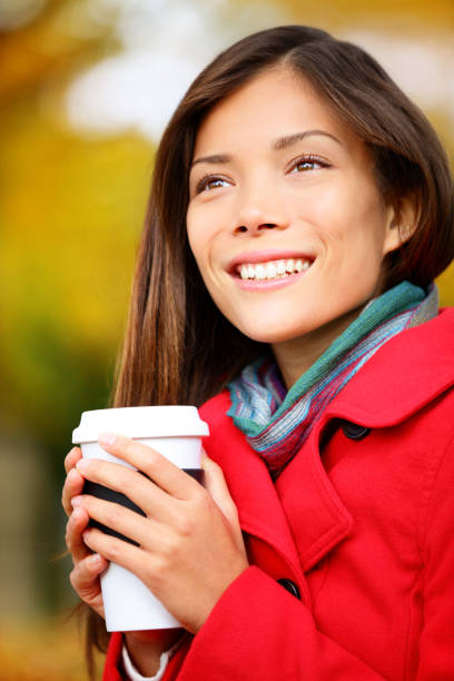 istock Autumn woman drinking coffee in fall city park 1171641388