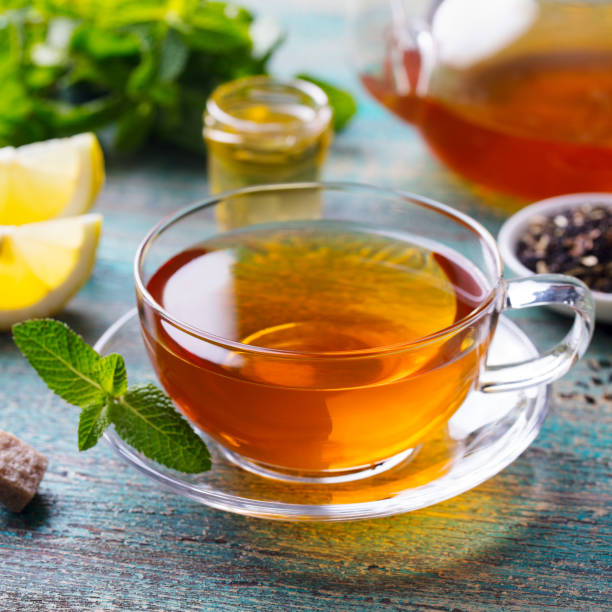 istock Tea cup with mint leaf and lemon. Wooden background. Close up. 1171641502