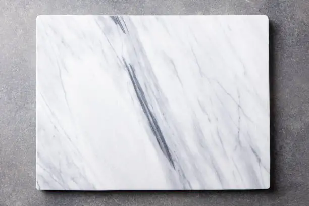 Photo of White marble texture board on grey background. Top view. Copy space.