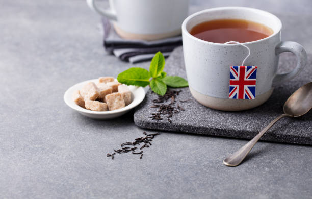 istock Tea in mugs with British flag tea bag label. Grey background. Copy space. 1171644698