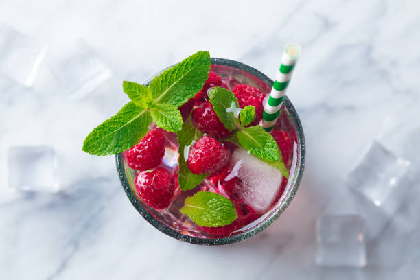 Raspberry cocktail, fizz, lemonade, ice tea with fresh mint. Marble background. Top view Copy space. Raspberry cocktail, fizz, lemonade, ice tea with fresh mint on marble background. Top view. Copy space vodka soda top view stock pictures, royalty-free photos & images