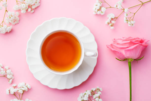 istock Cup of tea with fresh flowers on pink background. Copy space. Top view. 1171645065