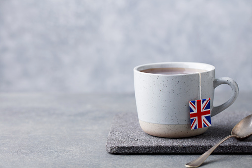 Té en taza con etiqueta de bolsa de té de la bandera británica. Fondo gris. Copiar espacio. photo