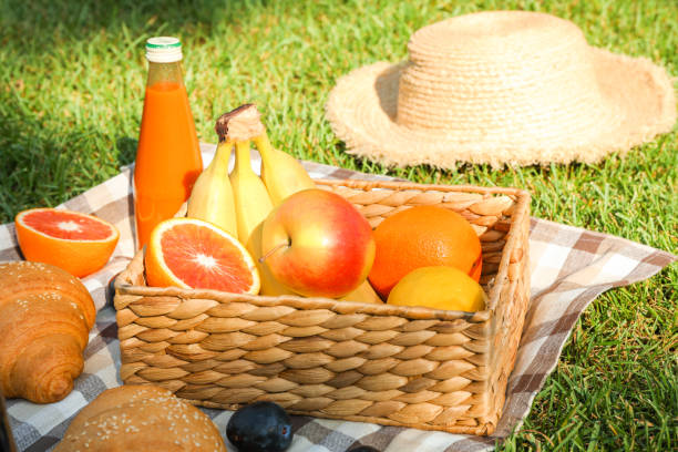 istock Picnic composition with fruits and straw hat against green grass, space for text 1171646651